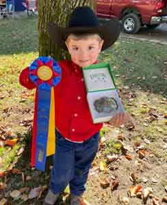 little boy showing off ribbon he won